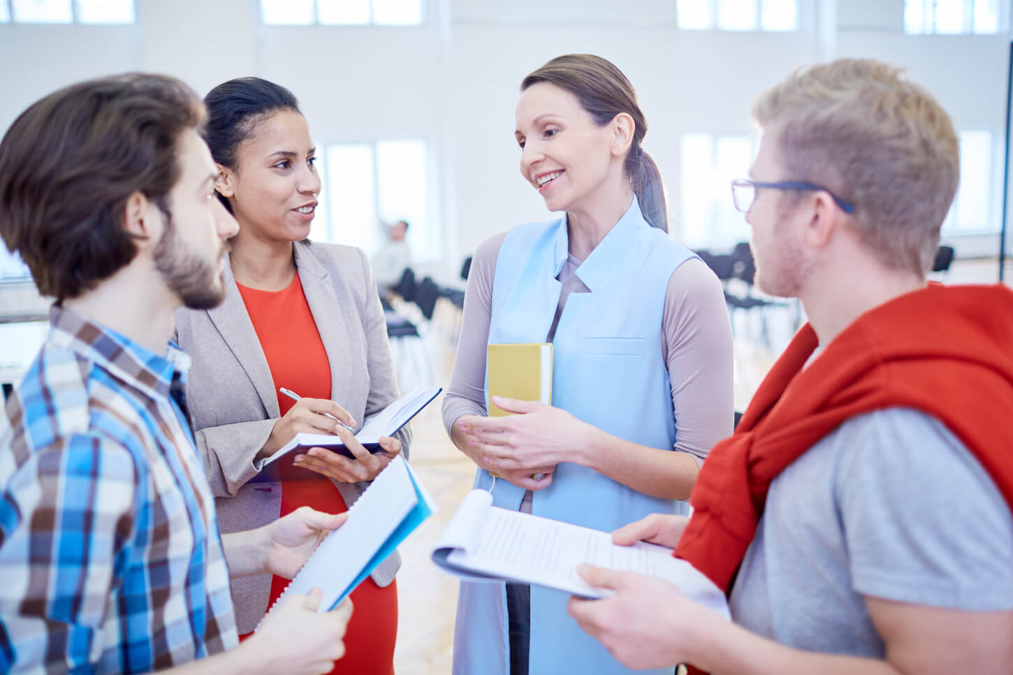 Nauczycielka rozmawia ze swoimi uczniami w ich firmie, oferując im naukę języka angielskiego dla firm.