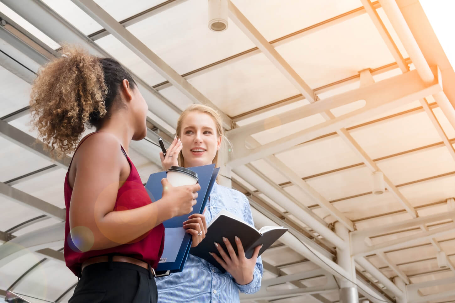 Dwie kobiety swobodnie komunikują się w języku angielskim, prawdopodobnie rozmawiają o codziennych sprawach, są w dobrym nastroju.