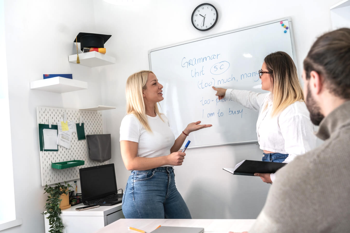 Uczennica wskazuje palcem na tablicę odpowiadając na pytanie zadane przez nauczycielkę angielskiego.